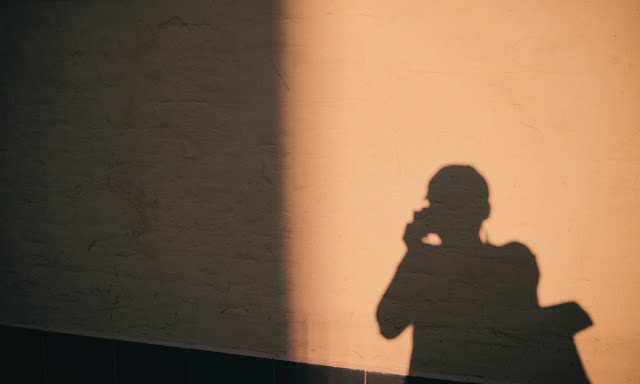A figure with a long shadow behind them, representing characters who carry unseen histories that deepen their presence A figure with a long shadow behind them, representing characters who carry unseen histories that deepen their presence